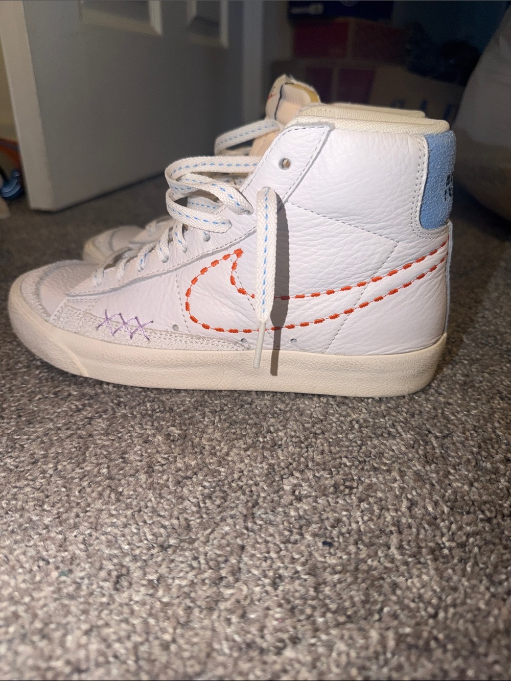 Nike White High-Top Sneakers with Orange Stitched Swoosh and Light Blue Heel